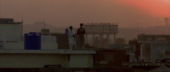 Movie still from “A Mighty Heart” (2007), directed by Michael Winterbottom – Two men standing on top of a building looking at a tablet computer; Extreme Wide shot, Low angle