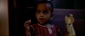 Movie still from “A Mighty Heart” (2007), directed by Michael Winterbottom – A little boy eating a piece of food; Close Up shot, High angle