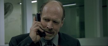 Movie still from “A Mighty Heart” (2007), directed by Michael Winterbottom – A man in a suit and tie talking on a cell phone; Close Up shot, Low angle