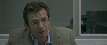 Movie still from “A Mighty Heart” (2007), directed by Michael Winterbottom – A person wearing glasses and a suit; Close Up shot, Over the shoulder angle