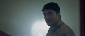 Movie still from “A Mighty Heart” (2007), directed by Michael Winterbottom – A person wearing a brown shirt; Close Up shot, Low angle