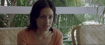 Movie still from “A Mighty Heart” (2007), directed by Michael Winterbottom – A person sitting on a chair in a room; Close Up shot, Over the shoulder angle