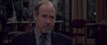 Movie still from “A Mighty Heart” (2007), directed by Michael Winterbottom – A man in a suit and tie looking to his left; Close Up shot, Over the shoulder angle