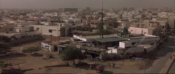 Movie still from “A Mighty Heart” (2007), directed by Michael Winterbottom – An aerial view of an urban area with many buildings; Extreme Wide shot, High angle