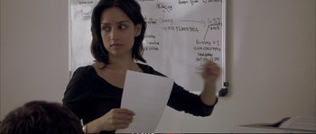 Movie still from “A Mighty Heart” (2007), directed by Michael Winterbottom – A woman holding a piece of paper standing in front of a whiteboard; Close Up shot, Over the shoulder angle