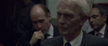 Movie still from “A Mighty Heart” (2007), directed by Michael Winterbottom – Two men in suits and ties looking at the camera; Close Up shot, Over the shoulder angle