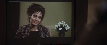Movie still from “A Mighty Heart” (2007), directed by Michael Winterbottom – A television screen with a woman smiling; Close Up shot, Over the shoulder angle