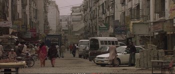 Movie still from “A Mighty Heart” (2007), directed by Michael Winterbottom – A busy city street filled with cars and pedestrians; Extreme Wide shot, High angle