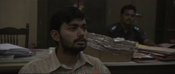 Movie still from “A Mighty Heart” (2007), directed by Michael Winterbottom – A man with a goatee is looking into the distance; Medium shot, Low angle