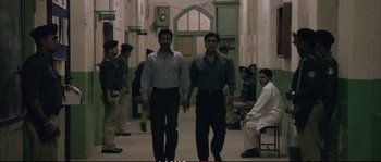 Movie still from “A Mighty Heart” (2007), directed by Michael Winterbottom – A couple of men walking down a hall way; Wide shot, High angle