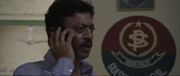 Movie still from “A Mighty Heart” (2007), directed by Michael Winterbottom – A person talking on a cell phone; Close Up shot, Over the shoulder angle