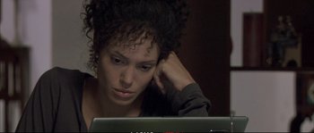 Movie still from “A Mighty Heart” (2007), directed by Michael Winterbottom – A woman is sitting in front of a computer; Close Up shot, High angle