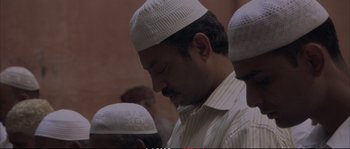 Movie still from “A Mighty Heart” (2007), directed by Michael Winterbottom – A group of men standing next to each other wearing white hats; Close Up shot, Low angle