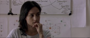 Movie still from “A Mighty Heart” (2007), directed by Michael Winterbottom – A woman sitting in front of a white board; Close Up shot, Over the shoulder angle