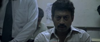 Movie still from “A Mighty Heart” (2007), directed by Michael Winterbottom – A person wearing a white shirt; Close Up shot, High angle