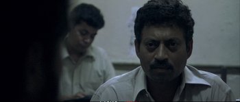 Movie still from “A Mighty Heart” (2007), directed by Michael Winterbottom – Two men sitting in front of each other in a room; Close Up shot, High angle