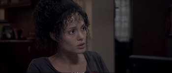 Movie still from “A Mighty Heart” (2007), directed by Michael Winterbottom – A person with curly black hair; Close Up shot, Over the shoulder angle