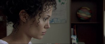 Movie still from “A Mighty Heart” (2007), directed by Michael Winterbottom – A person with curly black hair; Close Up shot, Over the shoulder angle