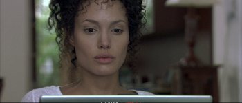 Movie still from “A Mighty Heart” (2007), directed by Michael Winterbottom – A person with curly hair looking at a computer screen; Close Up shot, Over the shoulder angle