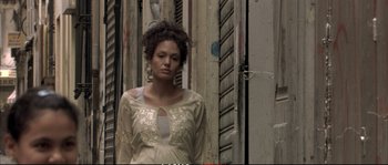 Movie still from “A Mighty Heart” (2007), directed by Michael Winterbottom – A woman standing in front of a building; Medium shot, Low angle