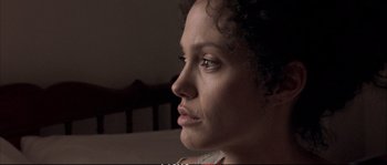 Movie still from “A Mighty Heart” (2007), directed by Michael Winterbottom – A woman's face in a dark room; Close Up shot, High angle
