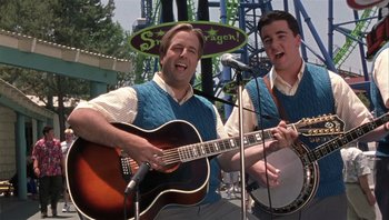 Movie still from “A Mighty Wind” (2003), directed by Christopher Guest – Two men sing and play guitar at a festival; Medium shot, Low angle