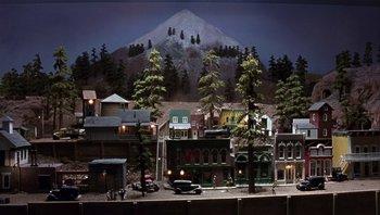 Movie still from “A Mighty Wind” (2003), directed by Christopher Guest – A model of a town with a mountain in the background; Extreme Wide shot, High angle
