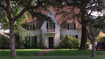 Movie still from “A Mighty Wind” (2003), directed by Christopher Guest – A large white house sitting on top of a lush green field; Extreme Wide shot, High angle