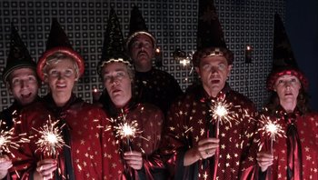 Movie still from “A Mighty Wind” (2003), directed by Christopher Guest – A group of men holding sparklers in their hands; Medium shot, Low angle