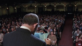 Movie still from “A Mighty Wind” (2003), directed by Christopher Guest – A crowd of people sitting in front of an audience; Wide shot, High angle