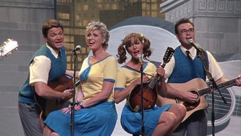 Movie still from “A Mighty Wind” (2003), directed by Christopher Guest – A group of people that are singing on stage; Wide shot, Overhead angle