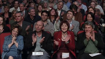Movie still from “A Mighty Wind” (2003), directed by Christopher Guest – A group of people clapping in front of an audience; Medium shot, High angle