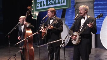 Movie still from “A Mighty Wind” (2003), directed by Christopher Guest – A group of men in suits and bow ties performing on stage; Medium shot, Low angle