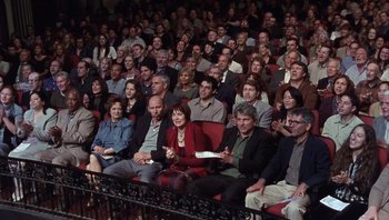 Movie still from “A Mighty Wind” (2003), directed by Christopher Guest – A large group of people sitting in a theater; Wide shot, High angle