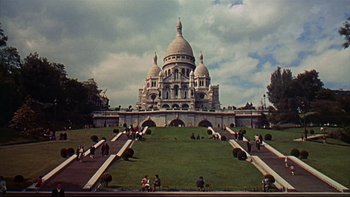 Movie still from “A New Kind of Love” (1963), directed by Melville Shavelson – People are sitting on the steps leading up to a large building; Extreme Wide shot, High angle