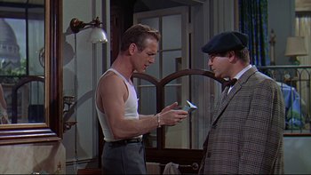 Movie still from “A New Kind of Love” (1963), directed by Melville Shavelson – A man in a white shirt and a man in a suit and tie; Medium shot, Over the shoulder angle