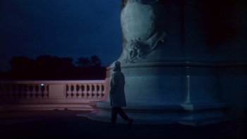 Movie still from “A New Kind of Love” (1963), directed by Melville Shavelson – A person walking in front of a large statue; Wide shot, Low angle