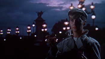 Movie still from “A New Kind of Love” (1963), directed by Melville Shavelson – A man holding a cigarette standing in the dark; Medium shot, Low angle