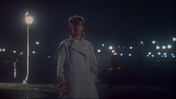 Movie still from “A New Kind of Love” (1963), directed by Melville Shavelson – A man in a trench coat standing in a parking lot at night; Medium shot, Low angle