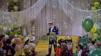 Movie still from “A New Kind of Love” (1963), directed by Melville Shavelson – A group of people sitting in front of a stage with bubbles; Wide shot, High angle