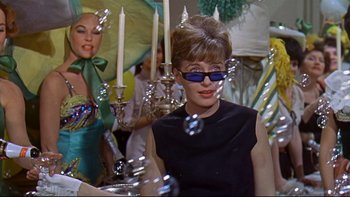 Movie still from “A New Kind of Love” (1963), directed by Melville Shavelson – A woman in a black dress and sunglasses; Medium shot, Low angle