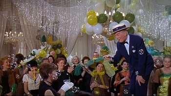 Movie still from “A New Kind of Love” (1963), directed by Melville Shavelson – A man in a suit and a top hat standing in front of a group of people; Medium shot, Low angle