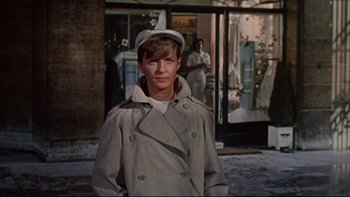 Movie still from “A New Kind of Love” (1963), directed by Melville Shavelson – A man wearing a trench coat and a hat; Medium shot, Low angle