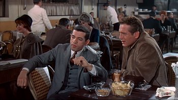 Movie still from “A New Kind of Love” (1963), directed by Melville Shavelson – Two men sitting at a table in a restaurant; Medium shot, Over the shoulder angle