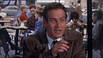 Movie still from “A New Kind of Love” (1963), directed by Melville Shavelson – A man holding a glass in his hand; Close Up shot, Over the shoulder angle