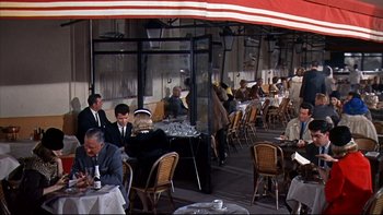 Movie still from “A New Kind of Love” (1963), directed by Melville Shavelson – A group of people sitting at tables outside of a restaurant; Wide shot, High angle