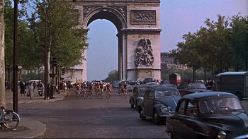 Movie still from “A New Kind of Love” (1963), directed by Melville Shavelson – A group of bicyclists riding through a triumphal arch; Extreme Wide shot, High angle