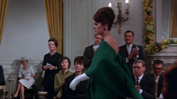 Movie still from “A New Kind of Love” (1963), directed by Melville Shavelson – An image of a woman in a green dress in front of a group of people; Medium shot, Low angle