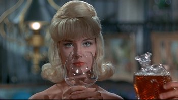 Movie still from “A New Kind of Love” (1963), directed by Melville Shavelson – A woman holding a wine glass in her hand; Close Up shot, Over the shoulder angle