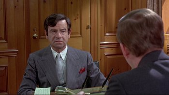 Movie still from “A New Leaf” (1971), directed by Elaine May – A man wearing a suit and tie in front of a mirror; Close Up shot, Over the shoulder angle